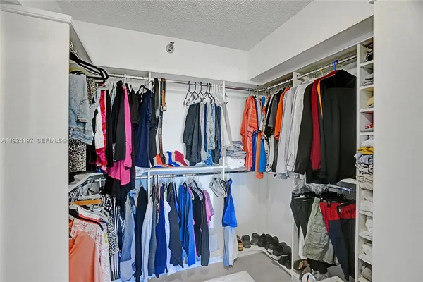 a view of walk in closet with clothes