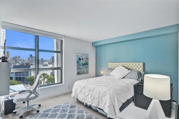 a bedroom with a large bed and a window