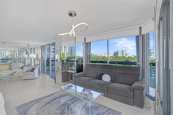 a living room with furniture ceiling fan and a large window