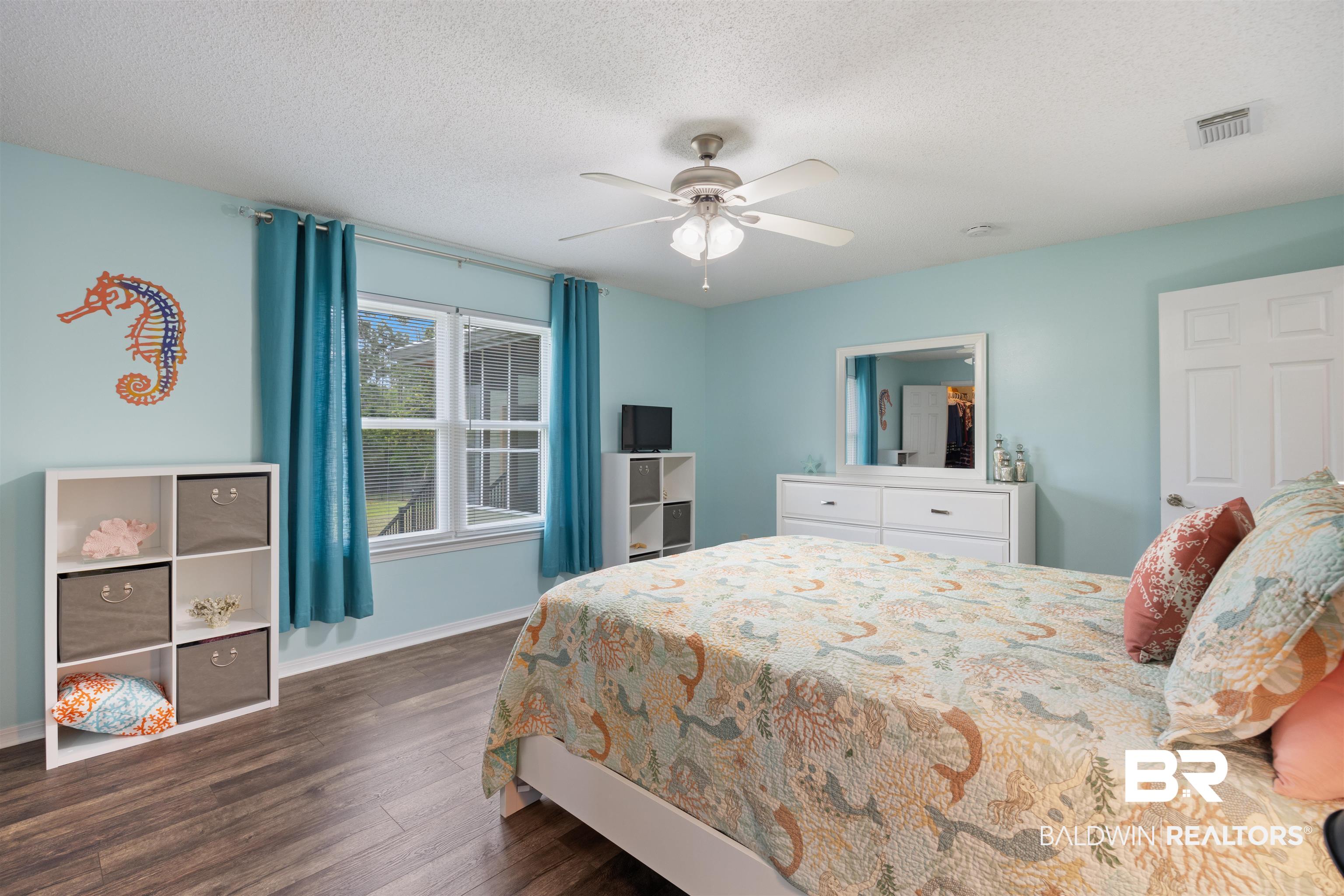 9771 Clarke Ridge Road Foley, AL 36535 - Photo 51 of 72 Bedroom featuring a ceiling fan, a textured ceiling, dark style flooring, and baseboards.