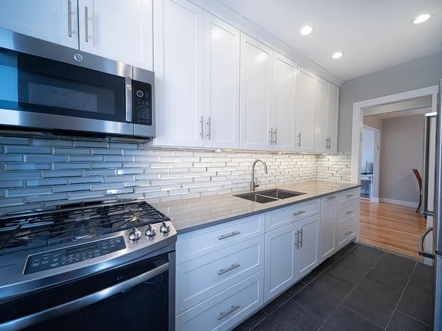 a kitchen with stainless steel appliances granite countertop a stove and a microwave