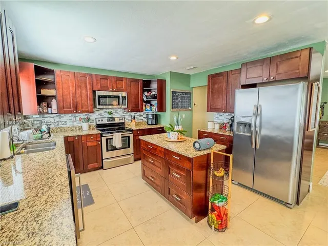 a kitchen with stainless steel appliances granite countertop a stove a sink dishwasher a refrigerator and a oven