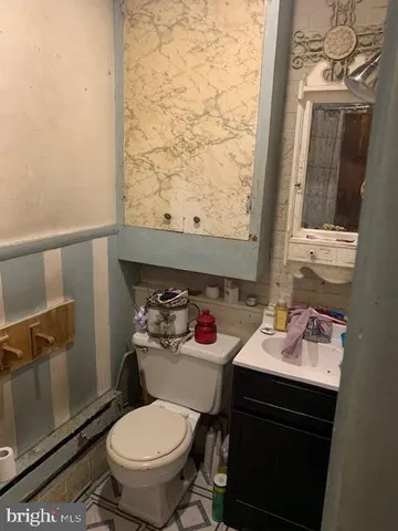 a bathroom with a sink toilet and a mirror