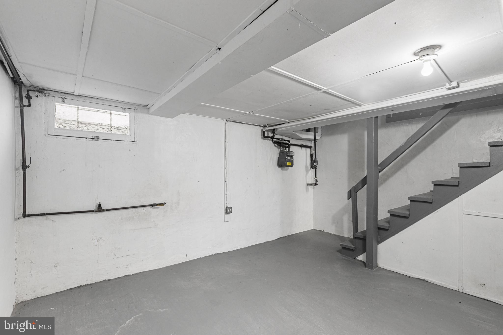 105 Upmanor Road Baltimore, MD 21229 - Photo 22 of 27 a view of a room with stairs and a refrigerator