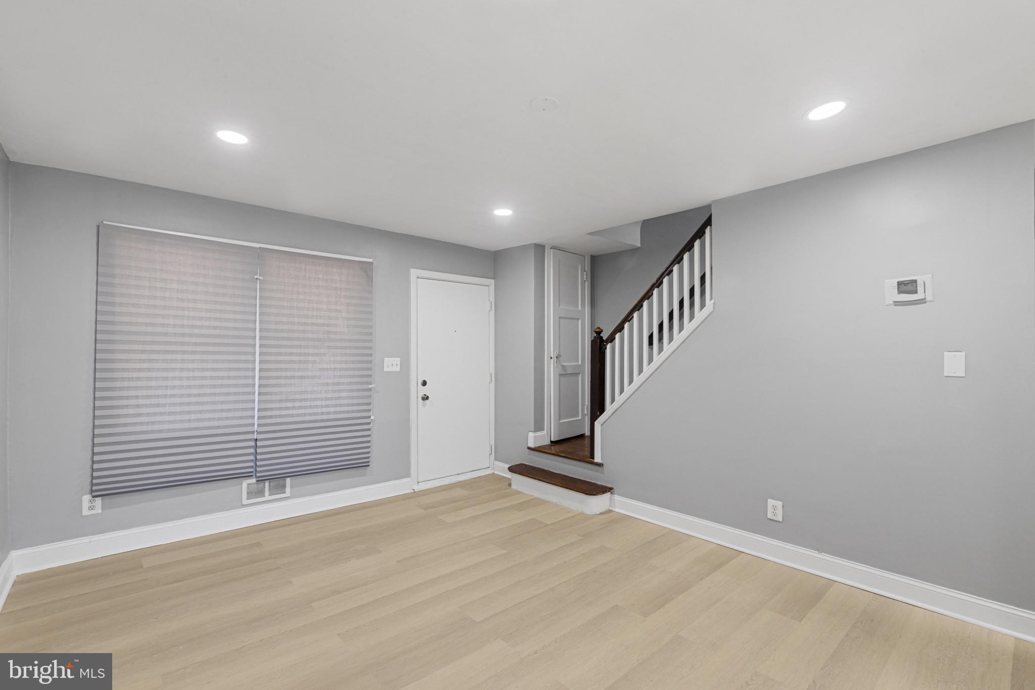 105 Upmanor Road Baltimore, MD 21229 - Photo 4 of 27 a view of an empty room with wooden floor and stairs