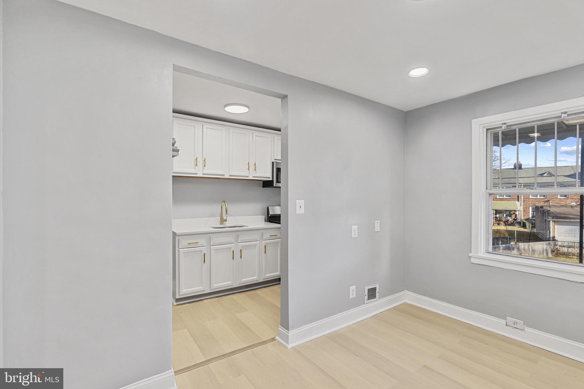 105 Upmanor Road Baltimore, MD 21229 - Photo 8 of 27 a kitchen with granite countertop white cabinets and window