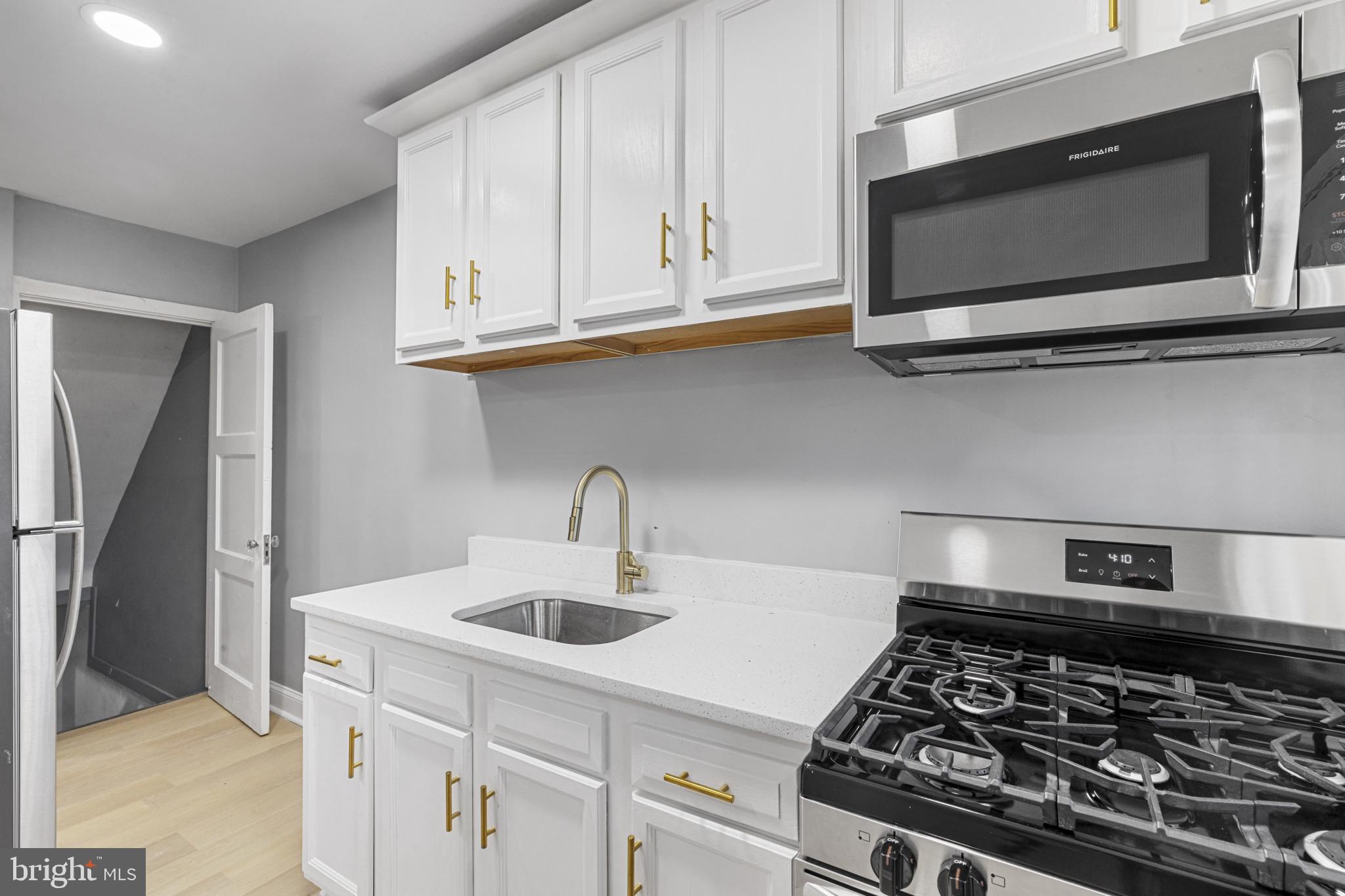 105 Upmanor Road Baltimore, MD 21229 - Photo 10 of 27 a kitchen with stainless steel appliances granite countertop a sink stove and microwave