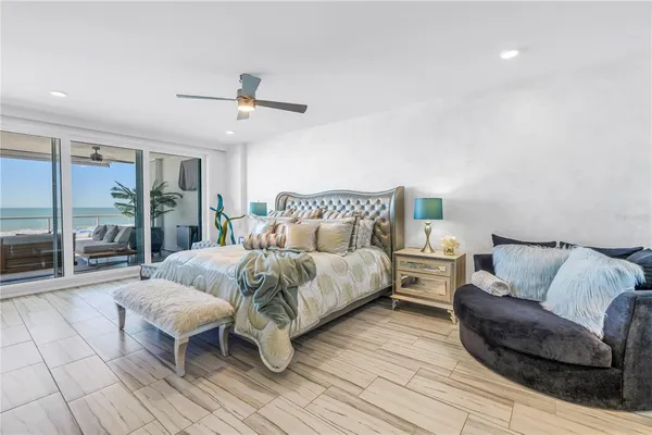 a spacious bedroom with a bed a couch and a large window