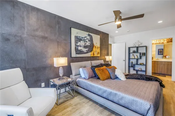 a bedroom with a bed ceiling fan and a closet