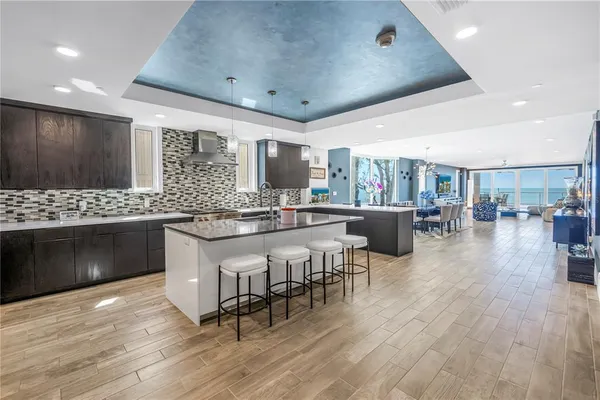 a kitchen with stainless steel appliances kitchen island granite countertop a stove a sink a dining table and chairs