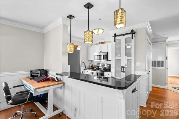 a room with a table chairs and a kitchen view