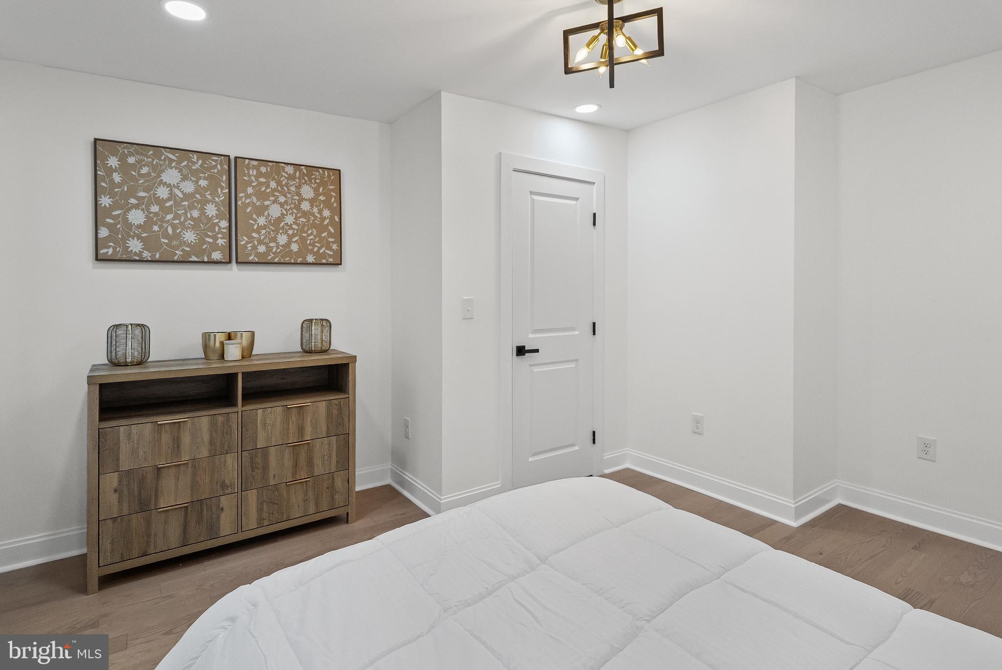 2428 East Biddle Street Baltimore, MD 21213 - Photo 13 of 26 a room with a bed and a chandelier