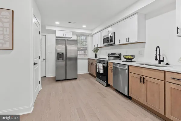 a kitchen with stainless steel appliances granite countertop a refrigerator and a sink