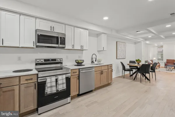 a kitchen with white cabinets and stainless steel appliances