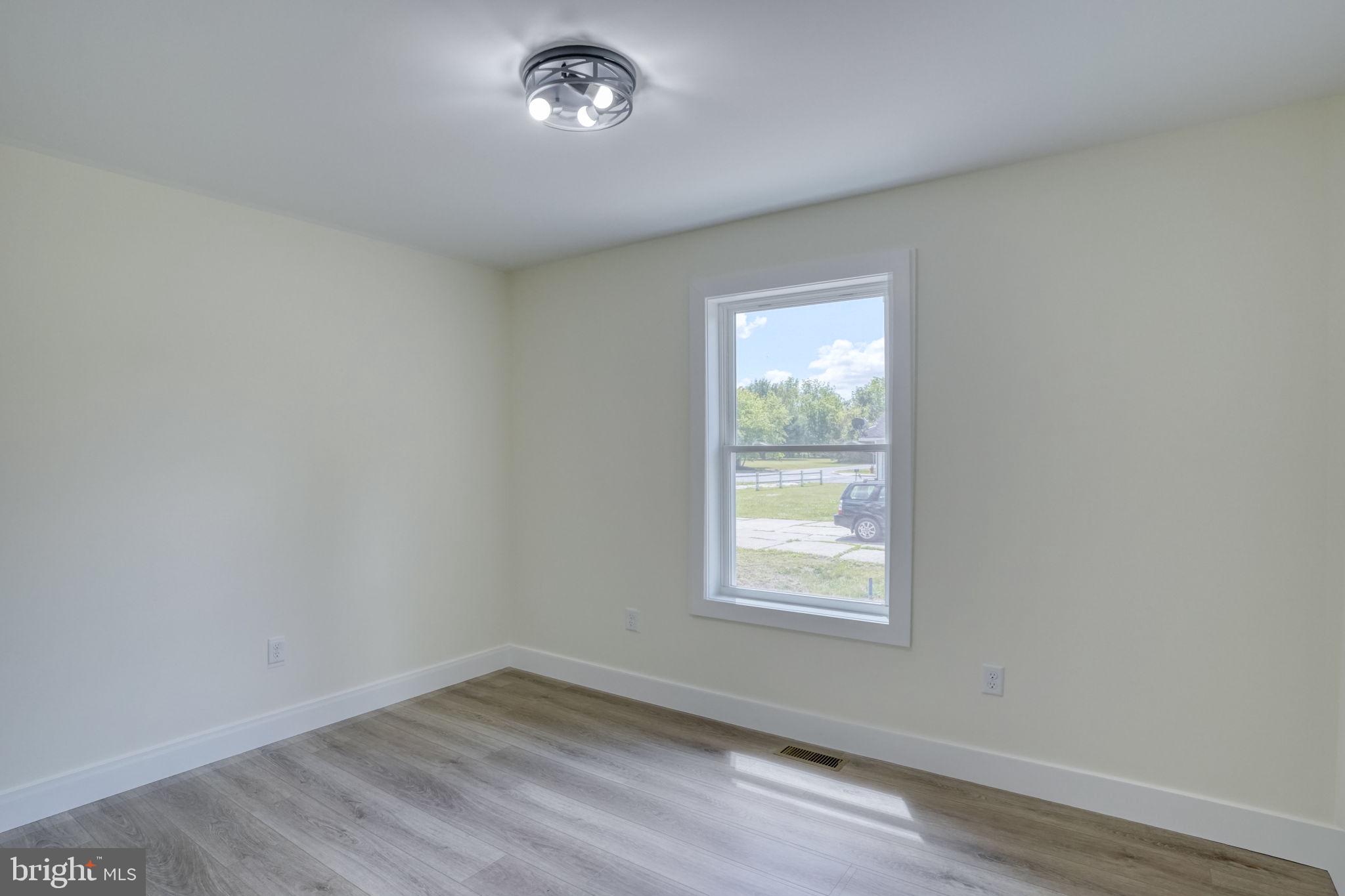 205 Charles Way Georgetown, DE 19947 - Photo 14 of 31 an empty room with wooden floor and windows