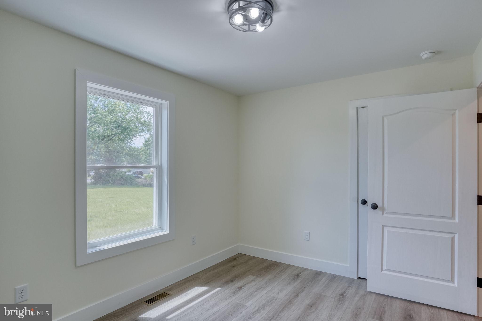 205 Charles Way Georgetown, DE 19947 - Photo 15 of 31 a view of an empty room with wooden floor and a window
