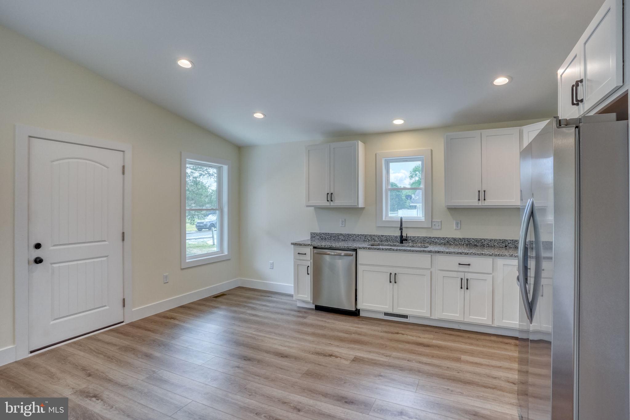 205 Charles Way Georgetown, DE 19947 - Photo 5 of 31 a kitchen with granite countertop white cabinets and wooden floor