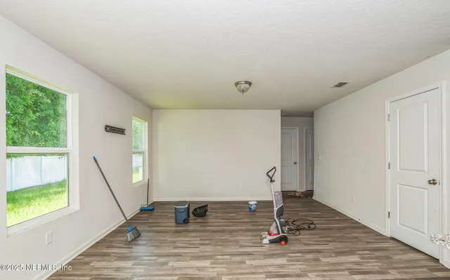 a room with lots of white furniture and wooden floor