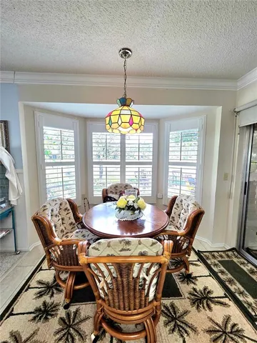 a dining room with furniture a chandelier and wooden floor