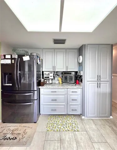 a kitchen with granite countertop a refrigerator and a stove top oven