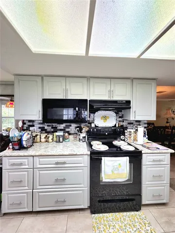 a kitchen with a stove and white cabinets