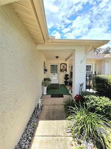 a view of a porch with chairs and potted plants
