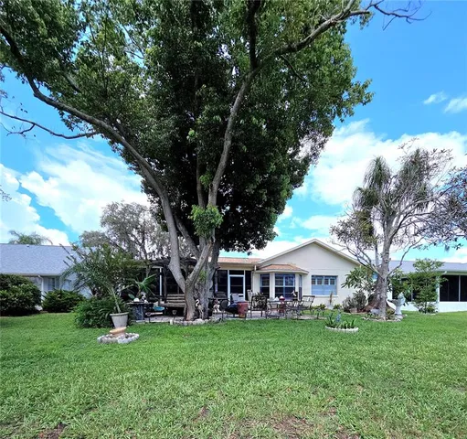 a view of a house with backyard garden and sitting area