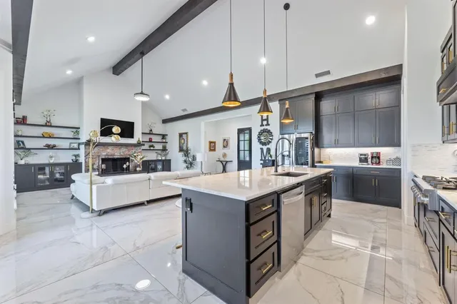 a kitchen with kitchen island a sink stove top oven and cabinets