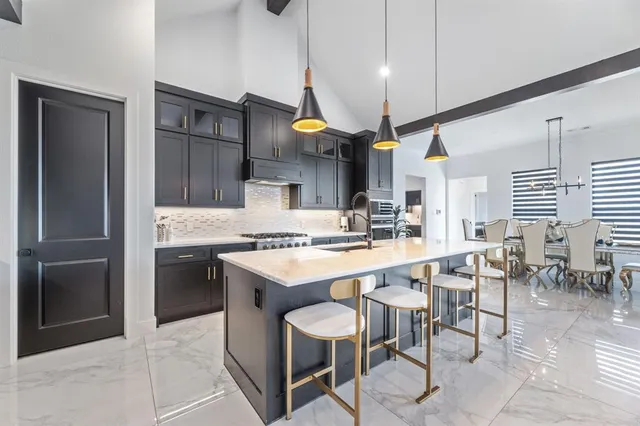 a kitchen with stainless steel appliances granite countertop a sink a stove and a refrigerator