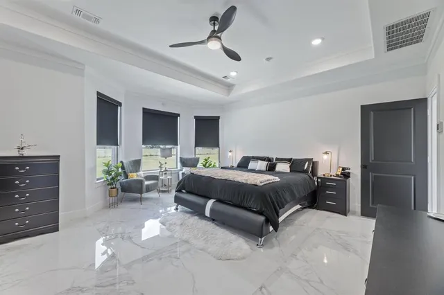 a spacious bedroom with a bed and ceiling fan