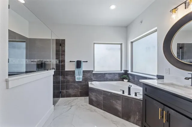 a spacious bathroom with a bathtub sink and mirror