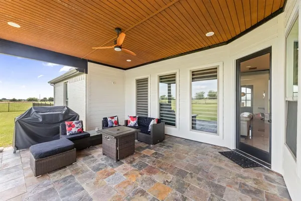 a living room with furniture a flat screen tv and floor to ceiling window