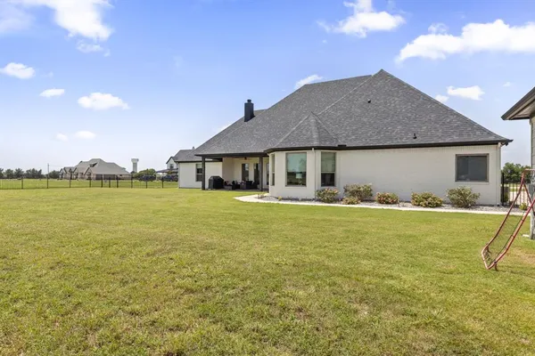 a front view of a house with a garden and lake view