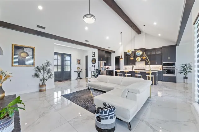 a living room with furniture kitchen view and a wooden floor