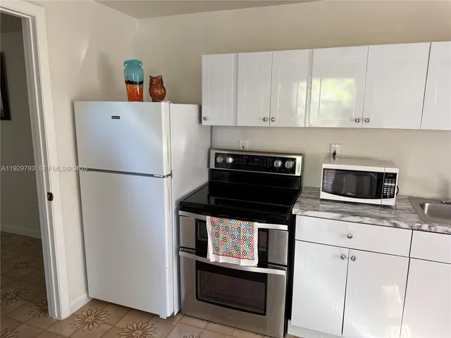 a kitchen with a refrigerator and cabinets