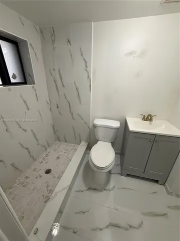 a bathroom with a toilet and a shower