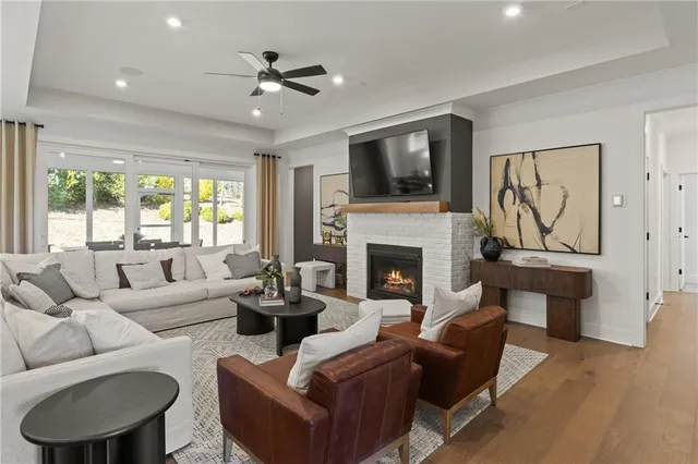 a living room with furniture a flat screen tv and a fireplace