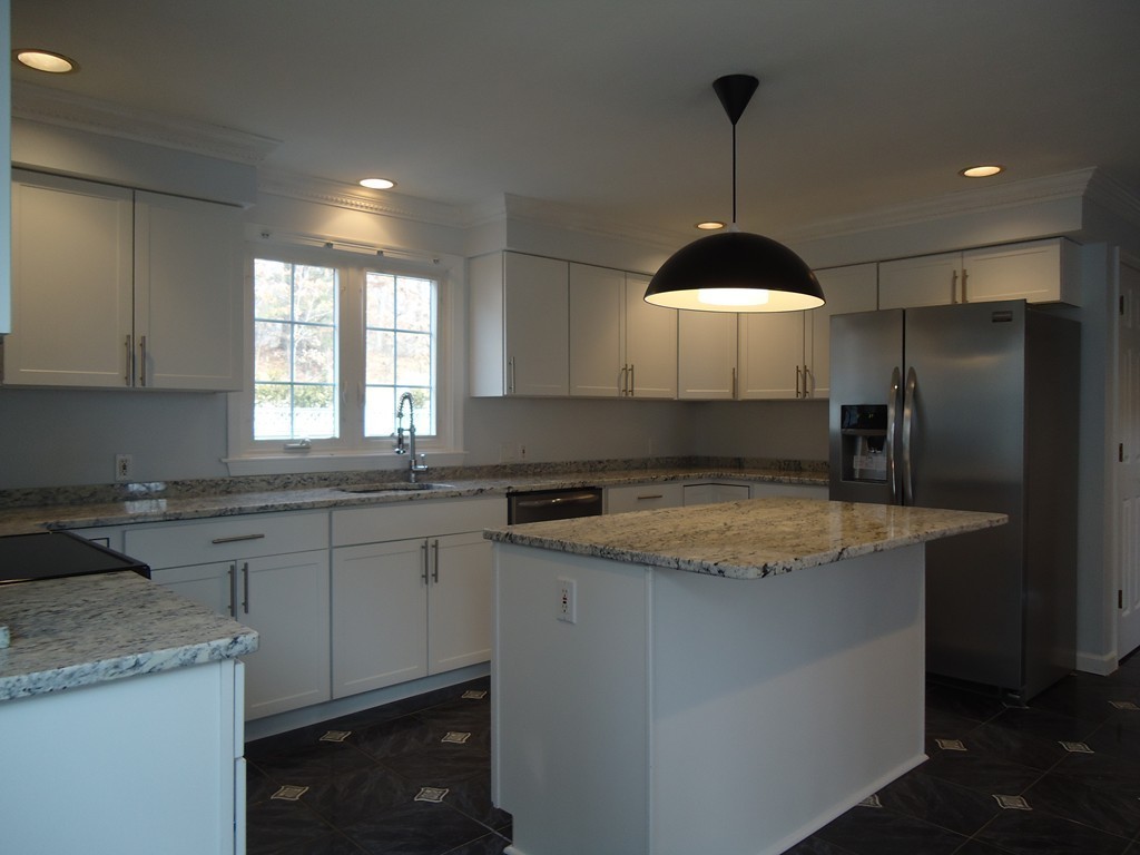 43 Parkland Road Needham, MA 02494 - Photo 12 of 30 a kitchen with a sink a center island and cabinets