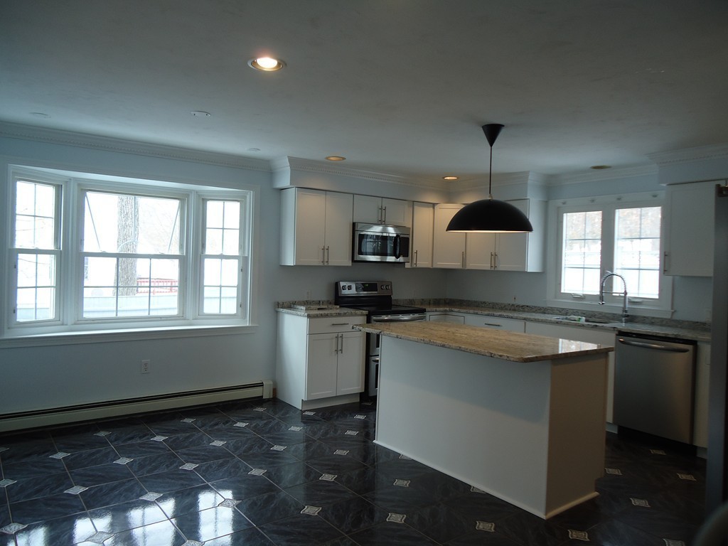 43 Parkland Road Needham, MA 02494 - Photo 10 of 30 a kitchen with granite countertop kitchen island stainless steel appliances a sink stove and a window