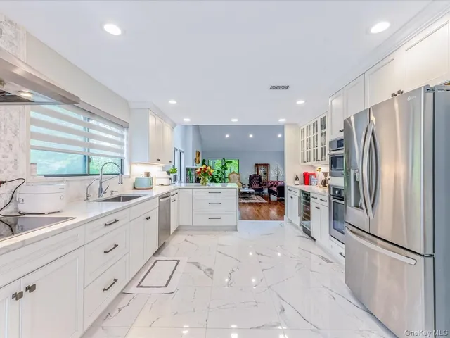 a kitchen with white cabinets and sink