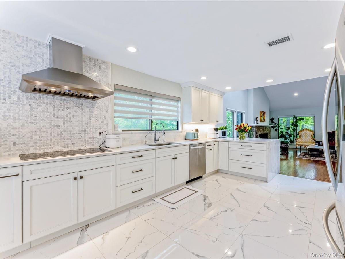 54 Harvard Road, Unit 54 Manhasset, NY 11030 - Photo 12 of 48 a kitchen with white cabinets and sink