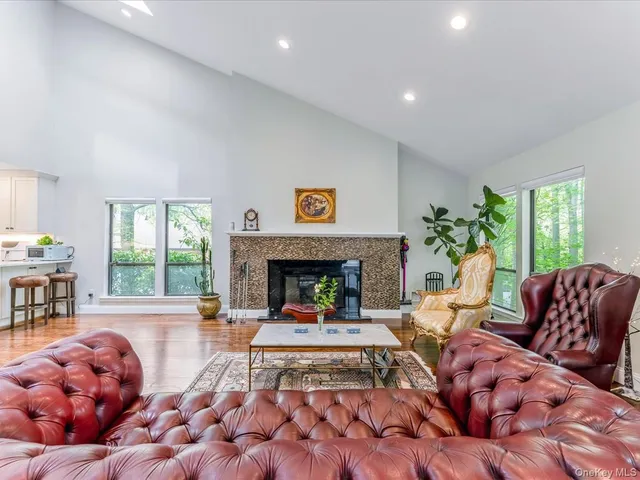 a living room with couches chairs and wooden floor