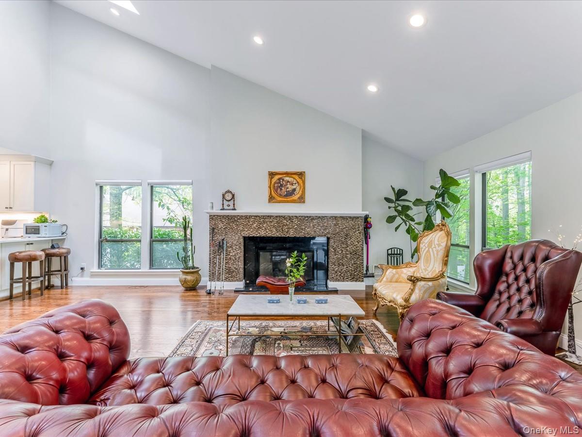 54 Harvard Road, Unit 54 Manhasset, NY 11030 - Photo 16 of 48 a living room with furniture large window and a fireplace