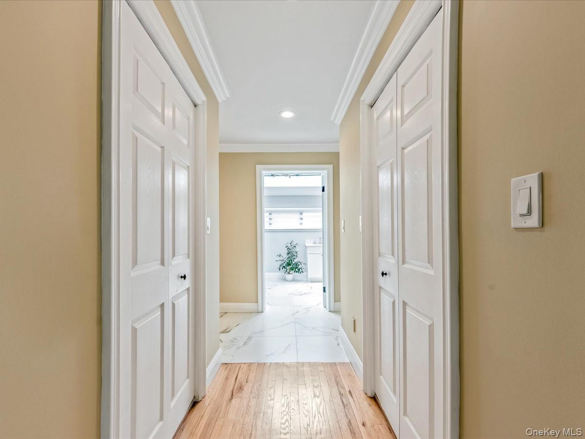 54 Harvard Road, Unit 54 Manhasset, NY 11030 - Photo 24 of 48 a view of a hallway with wooden floor and a bathroom