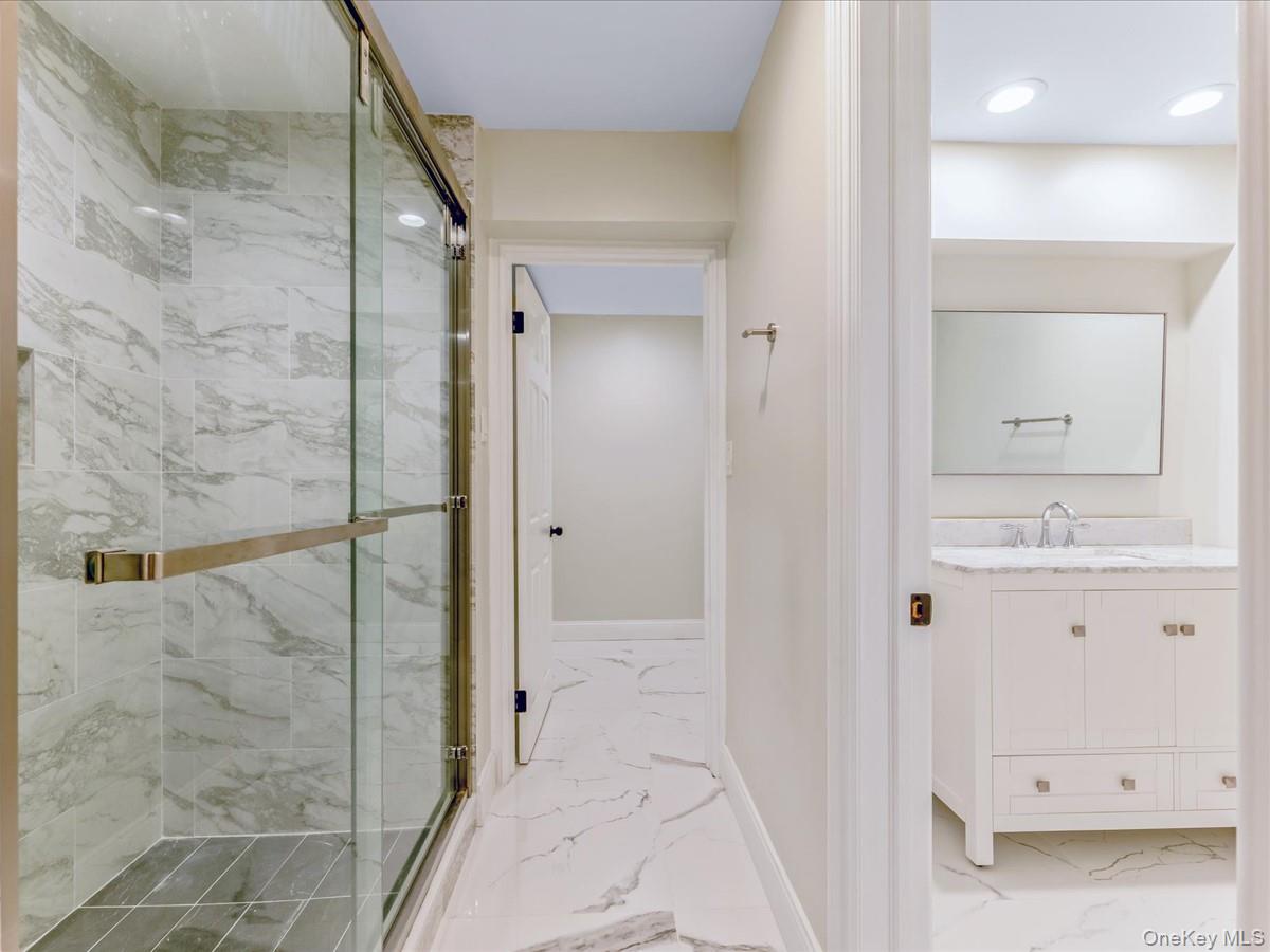 54 Harvard Road, Unit 54 Manhasset, NY 11030 - Photo 34 of 48 a bathroom with a granite countertop sink a mirror and a shower