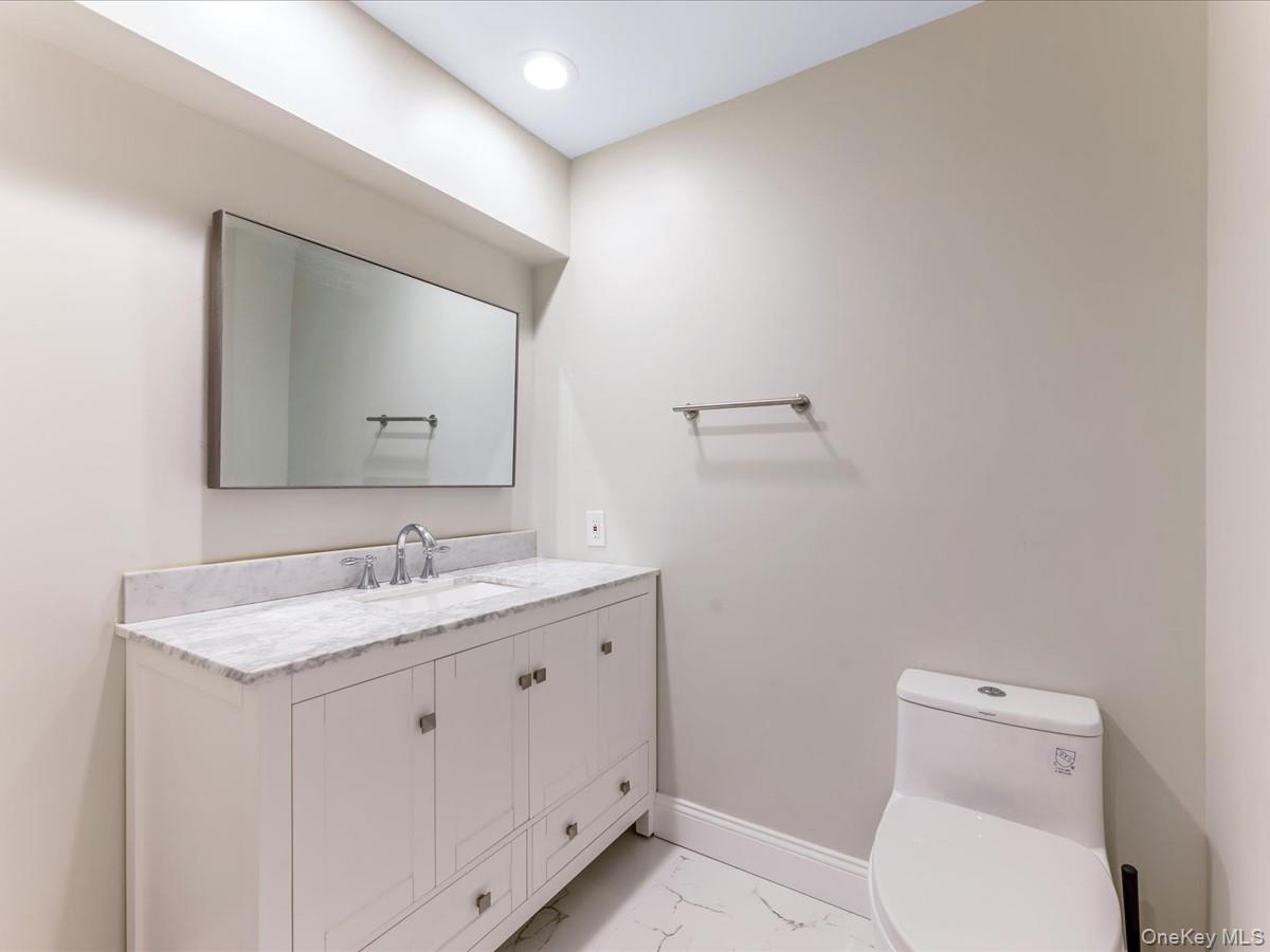 54 Harvard Road, Unit 54 Manhasset, NY 11030 - Photo 35 of 48 a bathroom with a toilet sink and mirror