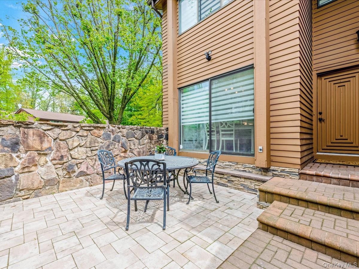 54 Harvard Road, Unit 54 Manhasset, NY 11030 - Photo 4 of 48 a patio with table and chairs and potted plants