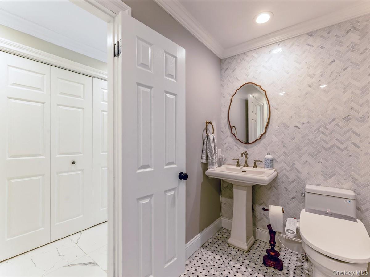 54 Harvard Road, Unit 54 Manhasset, NY 11030 - Photo 7 of 48 a bathroom with a sink a toilet and a mirror