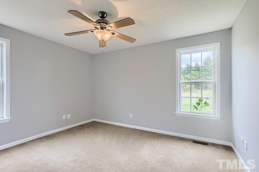 386 Rosa Circle Willow Spring, NC 27592 - Photo 20 of 27 an empty room with a window and a fan
