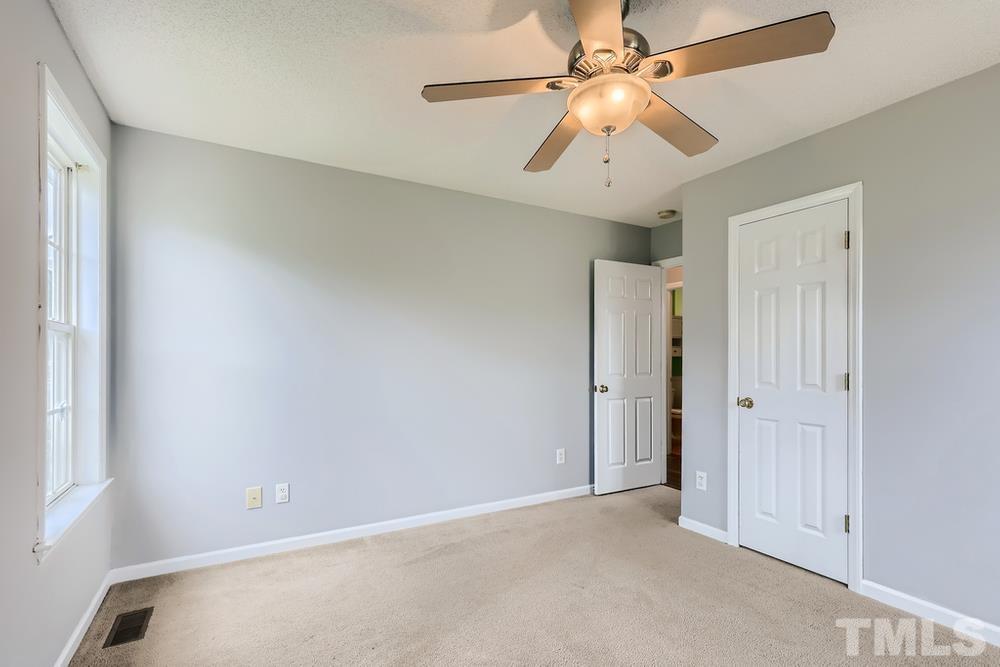 386 Rosa Circle Willow Spring, NC 27592 - Photo 21 of 27 an empty room with chandelier fan and windows